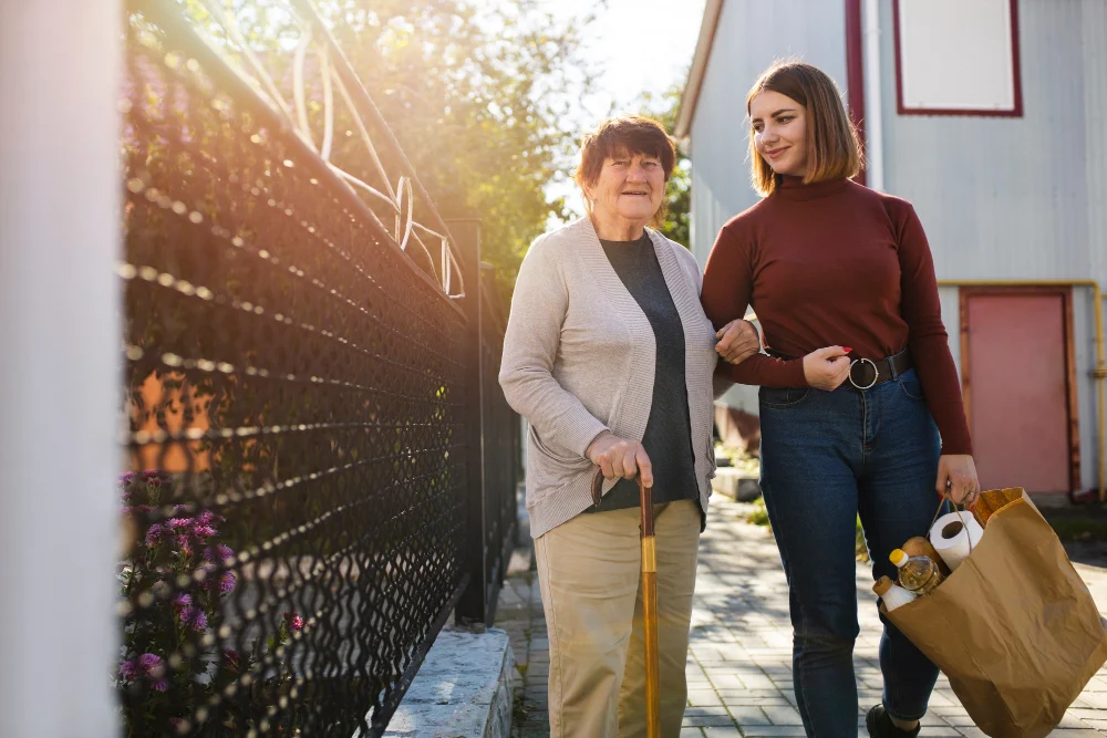 Elderly woman and support worker walking with groceries Elderly woman and support worker walking with groceries