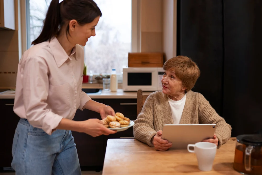Woman at table talking to support worker Woman at table talking to support worker