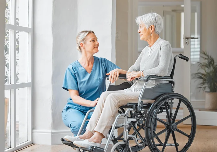 Aged care support worker helping an elderly person at home with daily tasks and transport support