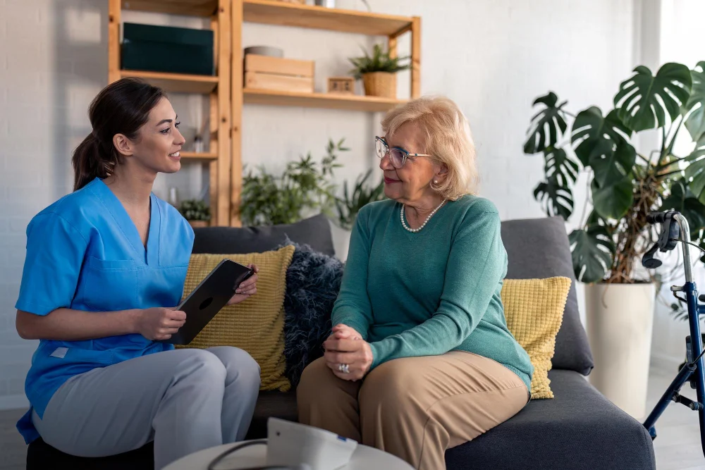 Older woman discussing aged care respite options with care worker at home