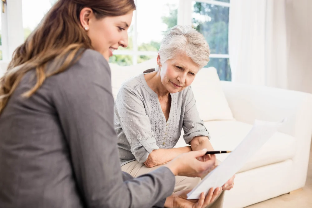 Older woman reviewing aged care fees with an adviser Older woman reviewing aged care fees with an adviser