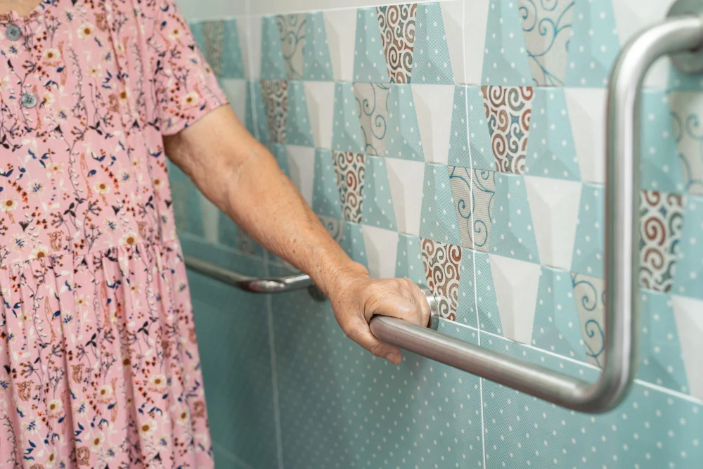 Older woman using grab rails in a home bathroom