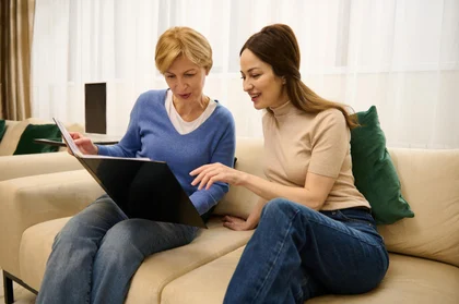 Family carer and older woman exploring respite care options together at home