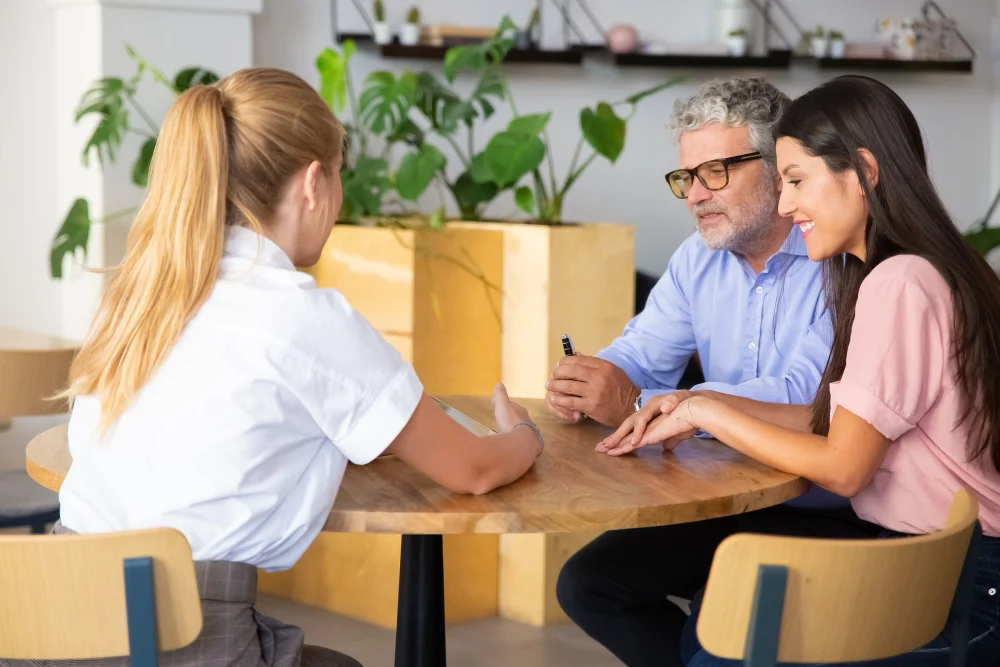 Support worker discussing care options with a man and woman at a table
