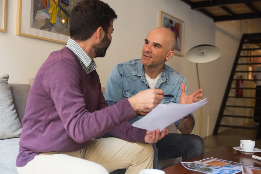 Two Men Discussing Paperwork at Home
